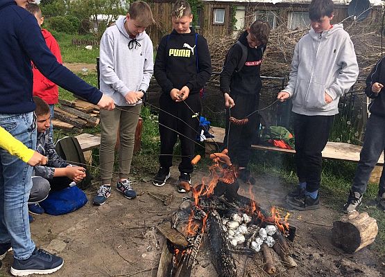 Chłopcy pieką kiełbaski