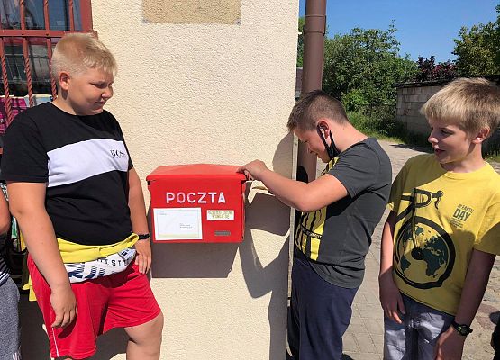 Chłopcy wrzucają kartki do skrzynki