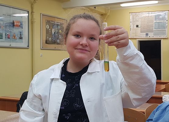 Karina pokazuje probówkę z gęstą cieczą