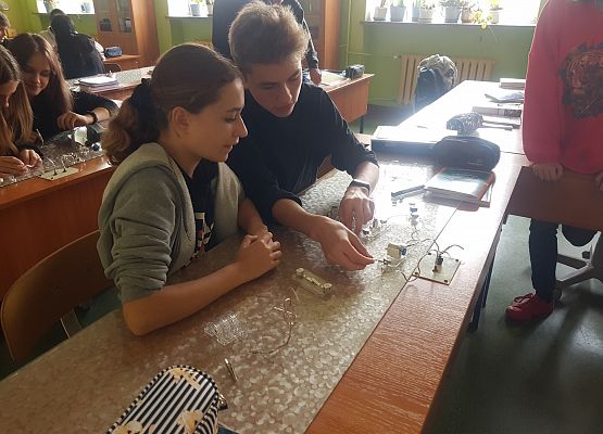 dziewczynka i chłopiec podłączają silniczek do zasilania