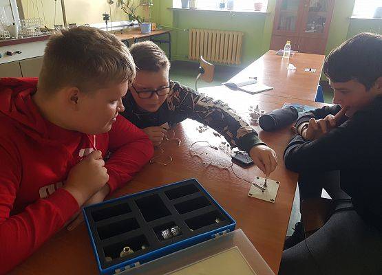 trzech chłopców buduje obwody elektryczne