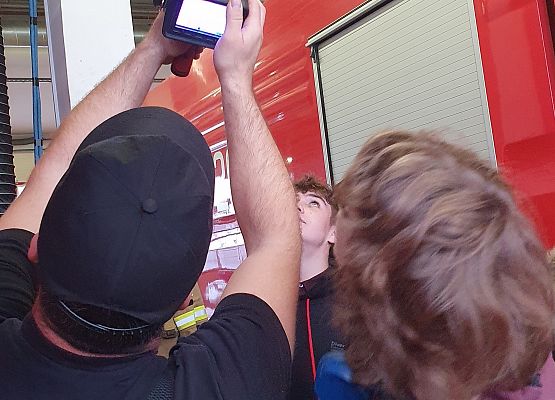 Strażak - sekc. A. Chołka, prezentuje działanie kamery termowizyjnej.