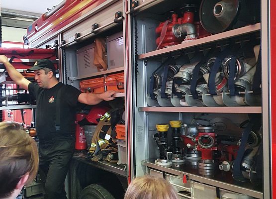 Uczniowie 8b oglądają wyposażenie wozu strażackiego.