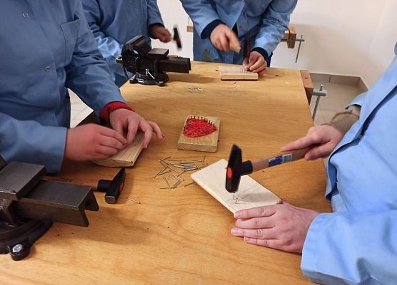 uczniowie wbijają gwoździe