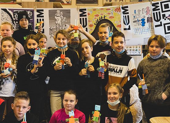 Dzieci z papierowymi robotami