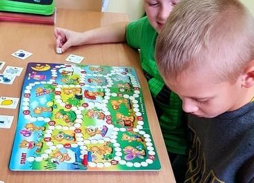 Uczniowie grają w grę planszową.