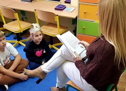 Uczniowie słuchają opowiadania o przygodach misia.