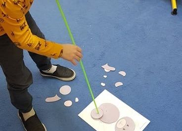 Olek układa misia z elementów.