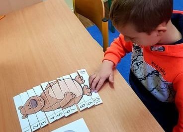 Filip  układa puzzle.