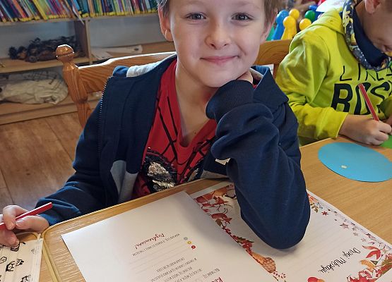 chłopiec rozmyśla o co poprosi Mikołaja