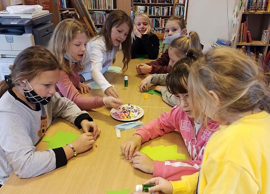 dziewczyny rozmyślają jakich kolorowych elementów użyć do ozdabiania choinek