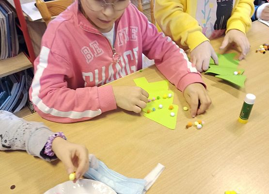 dzieci ozdabiają swoje papierowe choinki