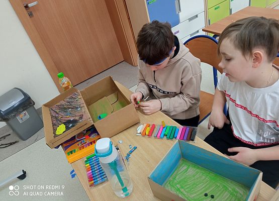 Jasiu i Wojtek pracują nad swoimi pudełkami