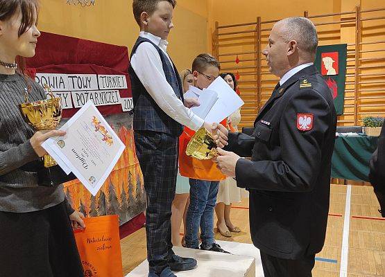 Komendant PSP w Lęborku Piotr Krzemiński wręcza puchar III m-ca uczestniczce Kajetanowi Garbaczewskiemu