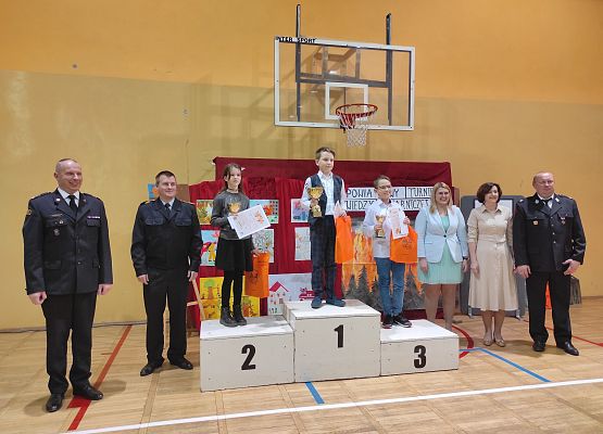 Zwycięzcy młodszej grupy wiekowej OTWP etap powiatowy na podium w towarzystwie organizatorów