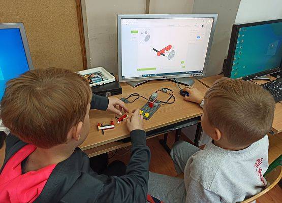 chłopacy budują i czytają instrukcje