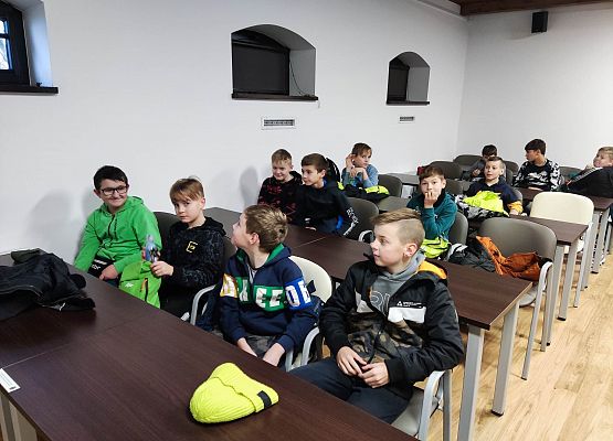 chłopcy siedzą w ławkach