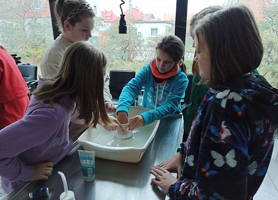 dziewczynki szukają mikroplastik w pilingu