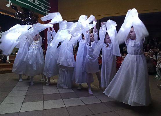 dziewczynki ubrane na biało tańczą ze świecącymi szarfami, podnoszą rączki