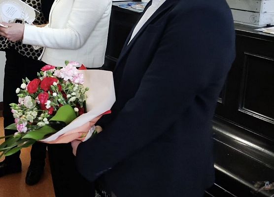 Dyrekcja z bukietem kwiatów i życzeniami