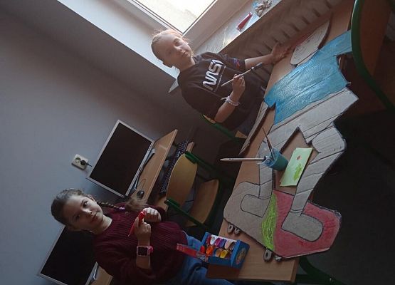 Uczennice malują farbami.