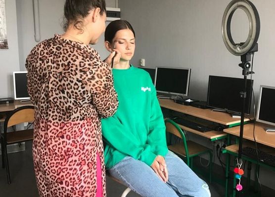 Kobieta maluje uczennice.