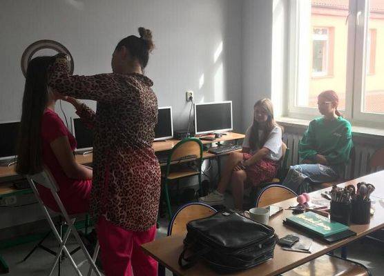 Kobieta maluje uczennice.