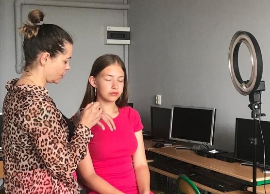 Kobieta maluje uczennice.