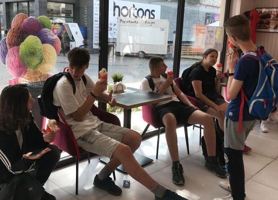 Uczniowie jedzą lody.