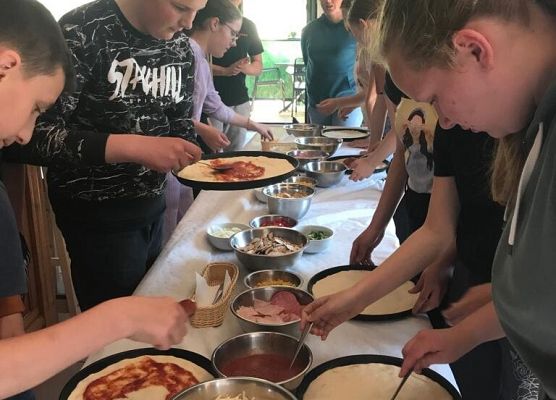 Uczniowie robią pizzę.