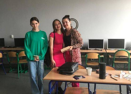 Kobieta i uczennice pozują do zdjęcia.