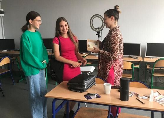 Kobieta i uczennice pozują do zdjęcia.