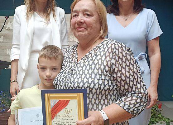 Aleksander Ostrowski z babcią odbiera nagrodę wzorowego ucznia