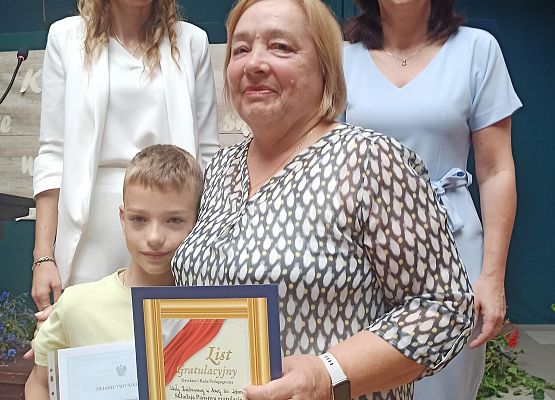 Aleksander Ostrowski z babcią odbiera nagrodę wzorowego ucznia