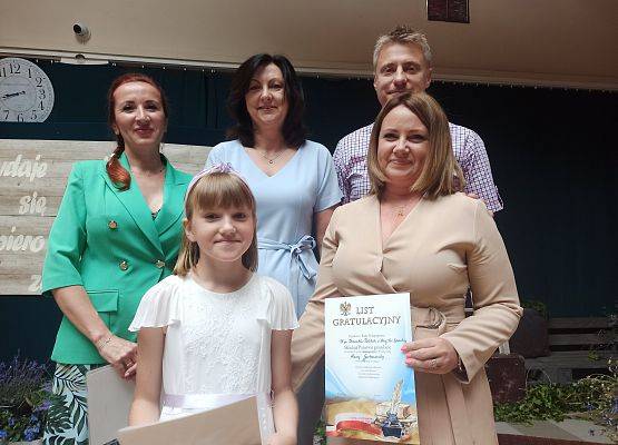 Hania Garbaczewska z rodzicami odbiera nagrodę wzorowego ucznia