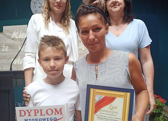 Maksymilian Kobiela z mamą odbiera nagrodę wzorowego ucznia