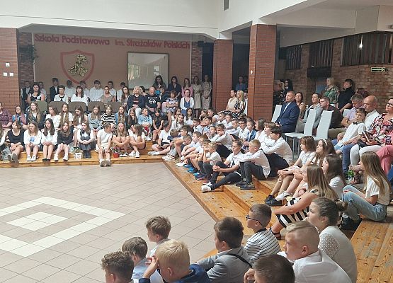 Uczniowie i rodzice siedzący na apelu