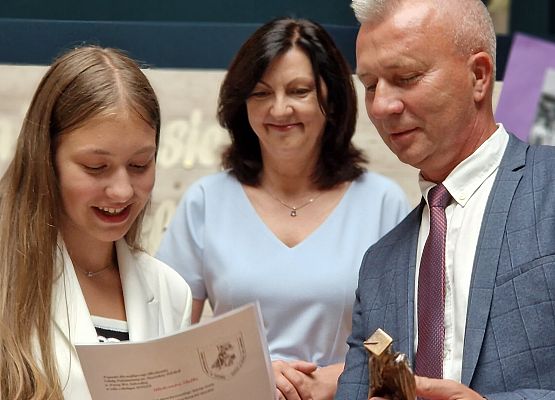 Pan Marek Baranowski wręcza Oli nagrodę