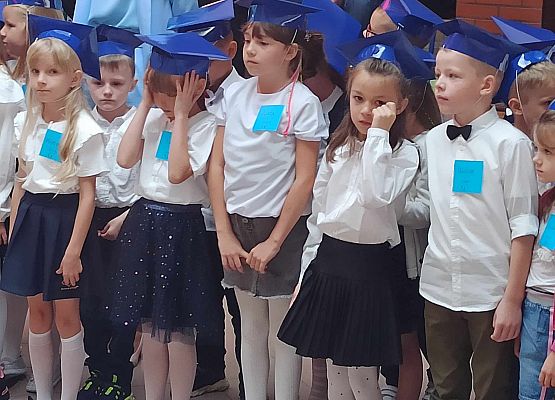 pierwszoklasiści w niebieskich czapkach