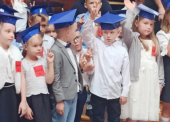 dzieci ślubują i podnoszą roczki