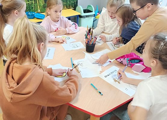 Uczniowie malują emotki.