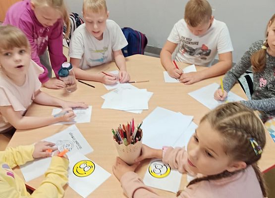 Uczniowie malują emotki podczas przerwy.