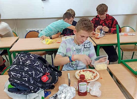 Adrian Jaskulka, Michał Kulasiewicz, Olek Ruszewski przygotowują pizzę