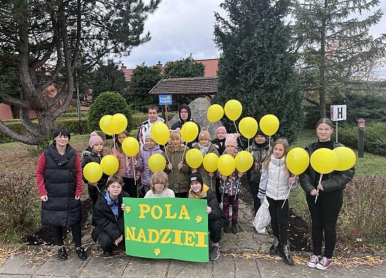 Grupa uczniów stoi o trzyma w ręku balony