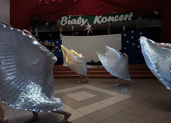 taniec dziewczynek z klas 1-3 ze świecącymi skrzydłami