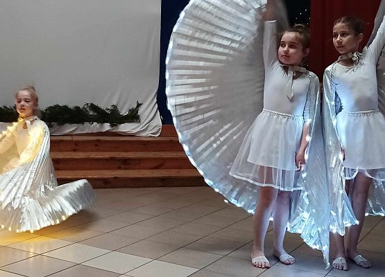 taniec dziewczynek z klas 1-3 ze świecącymi skrzydłami