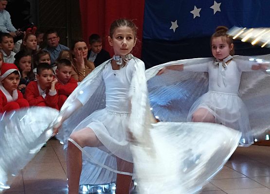 taniec dziewczynek z klas 1-3 ze świecącymi skrzydłami