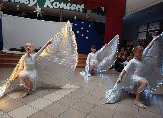 taniec dziewczynek z klas 1-3 ze świecącymi skrzydłami