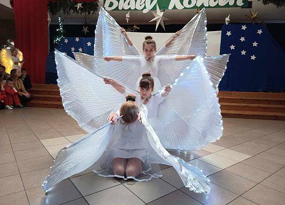 taniec dziewczynek z klas 1-3 ze świecącymi skrzydłami