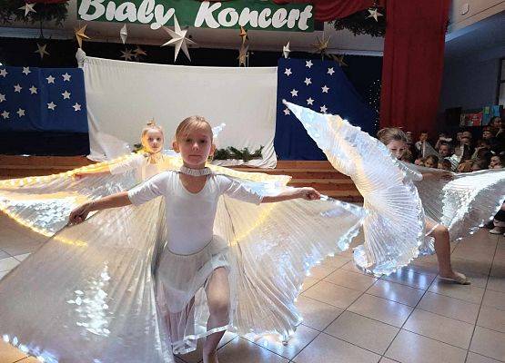 taniec dziewczynek z klas 1-3 ze świecącymi skrzydłami